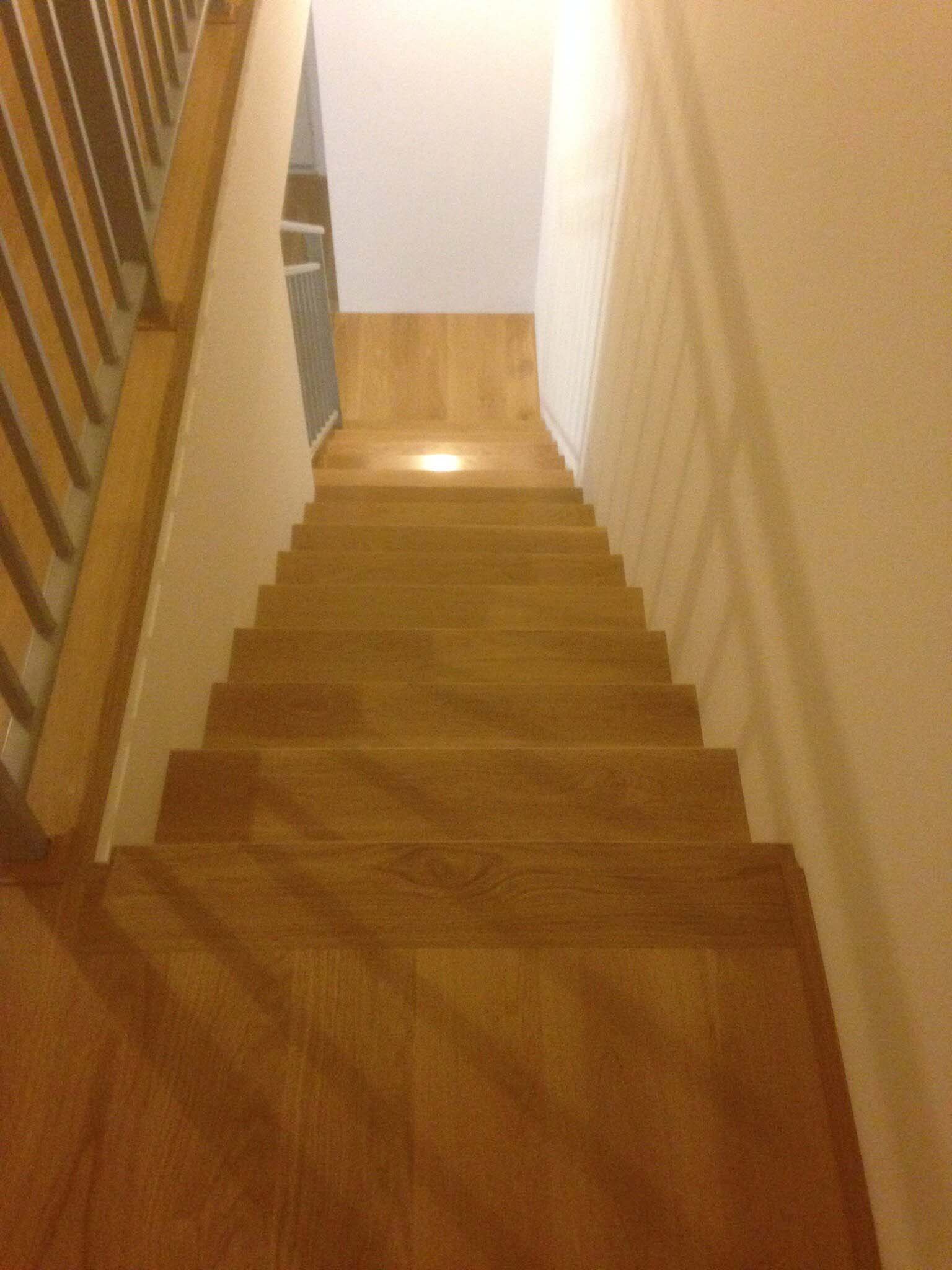 Narrow timber staircase with step lights, viewed from the top