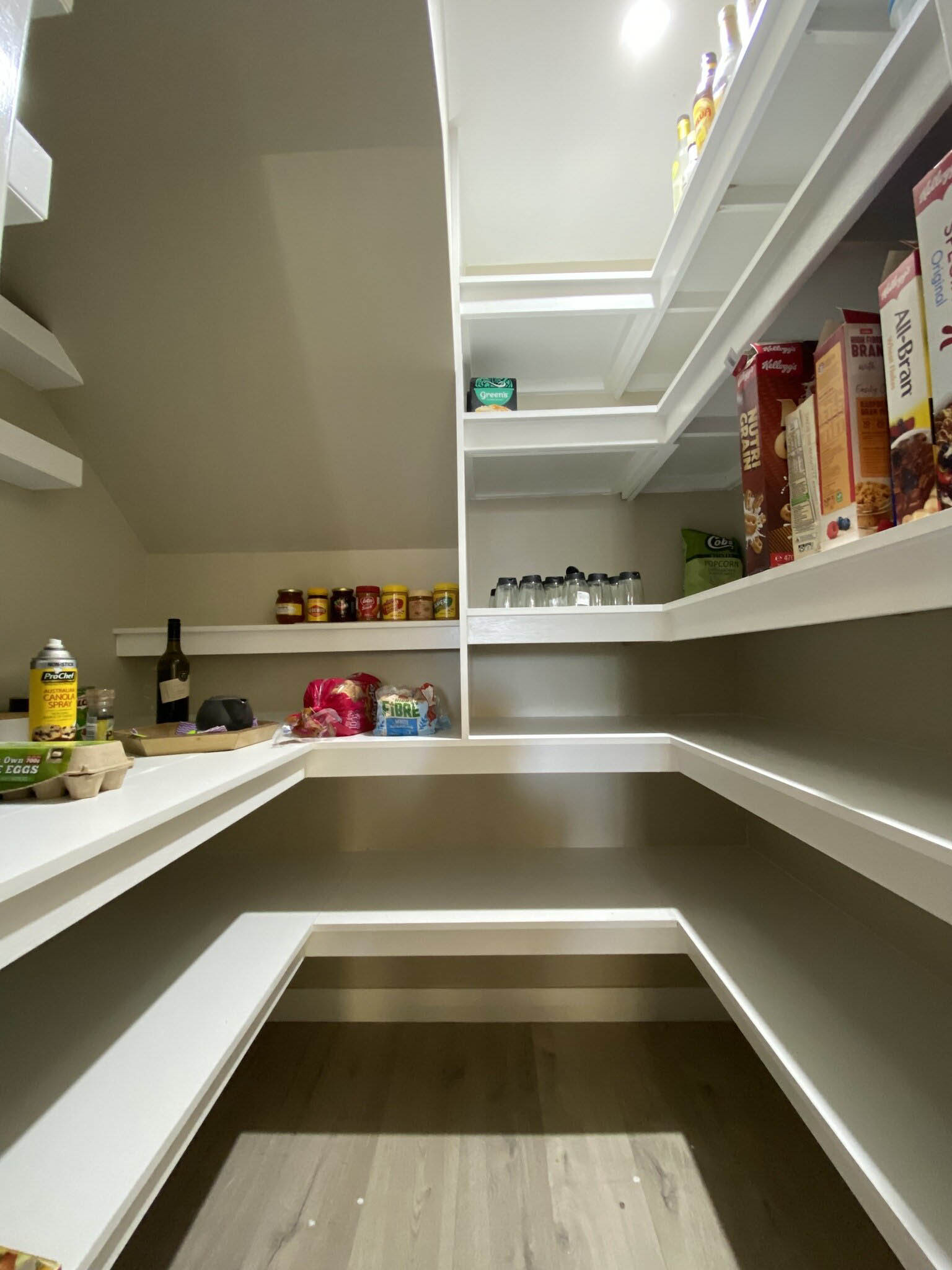 Walk-in pantry with white wraparound shelving
