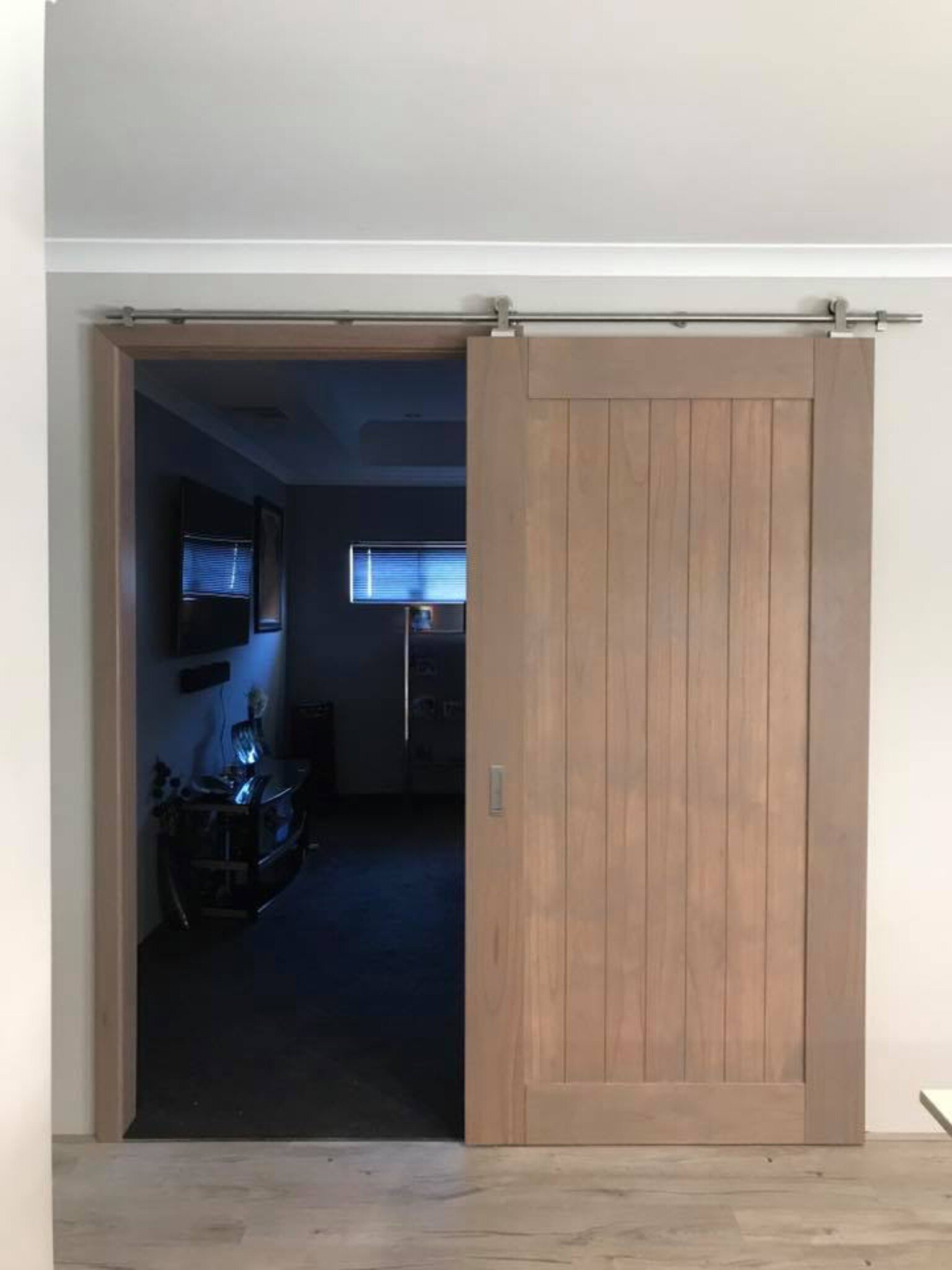 Timber barn door on a sliding track across a doorway