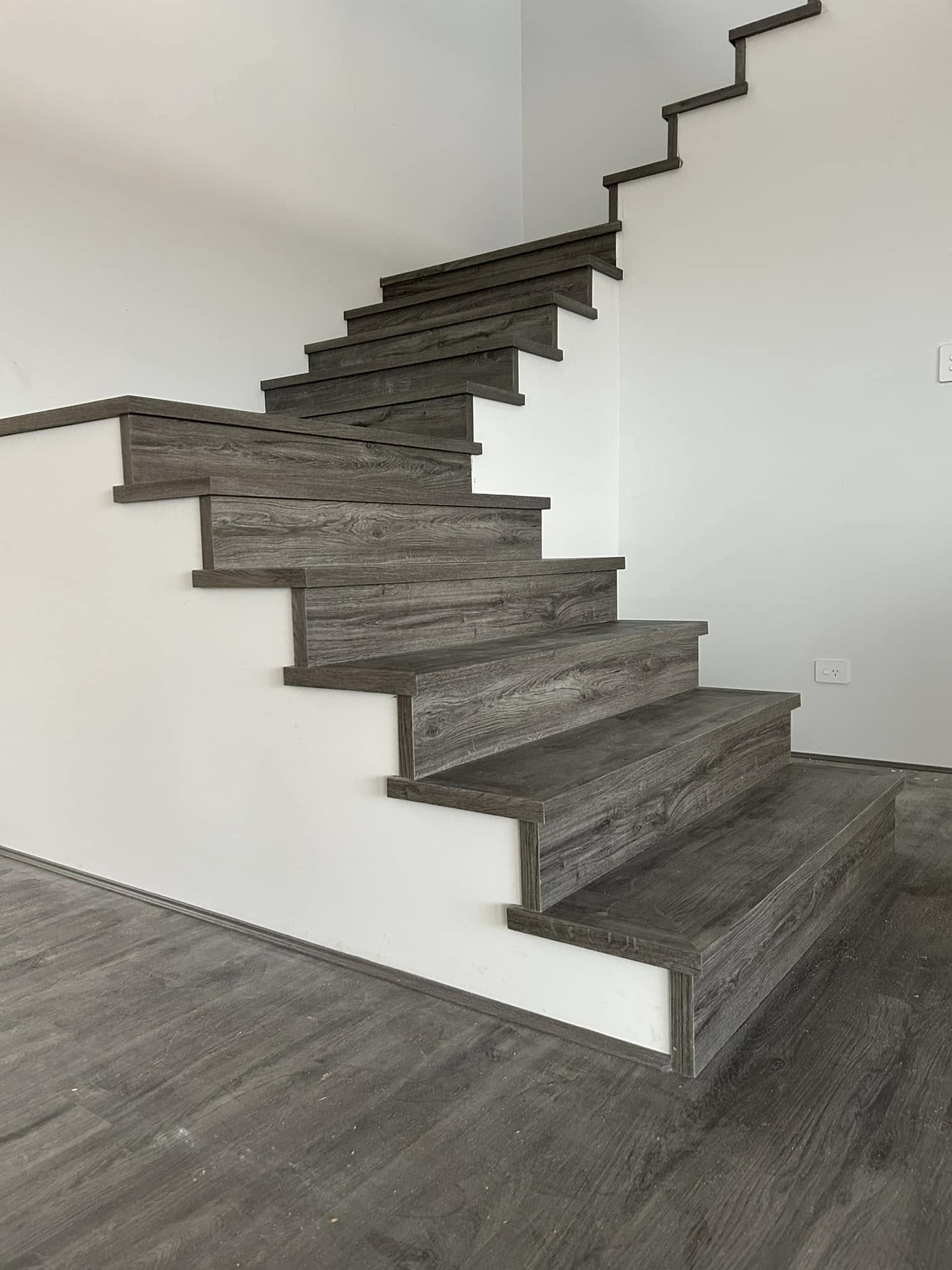 Staircase with grey timber-look treads matching the floor below