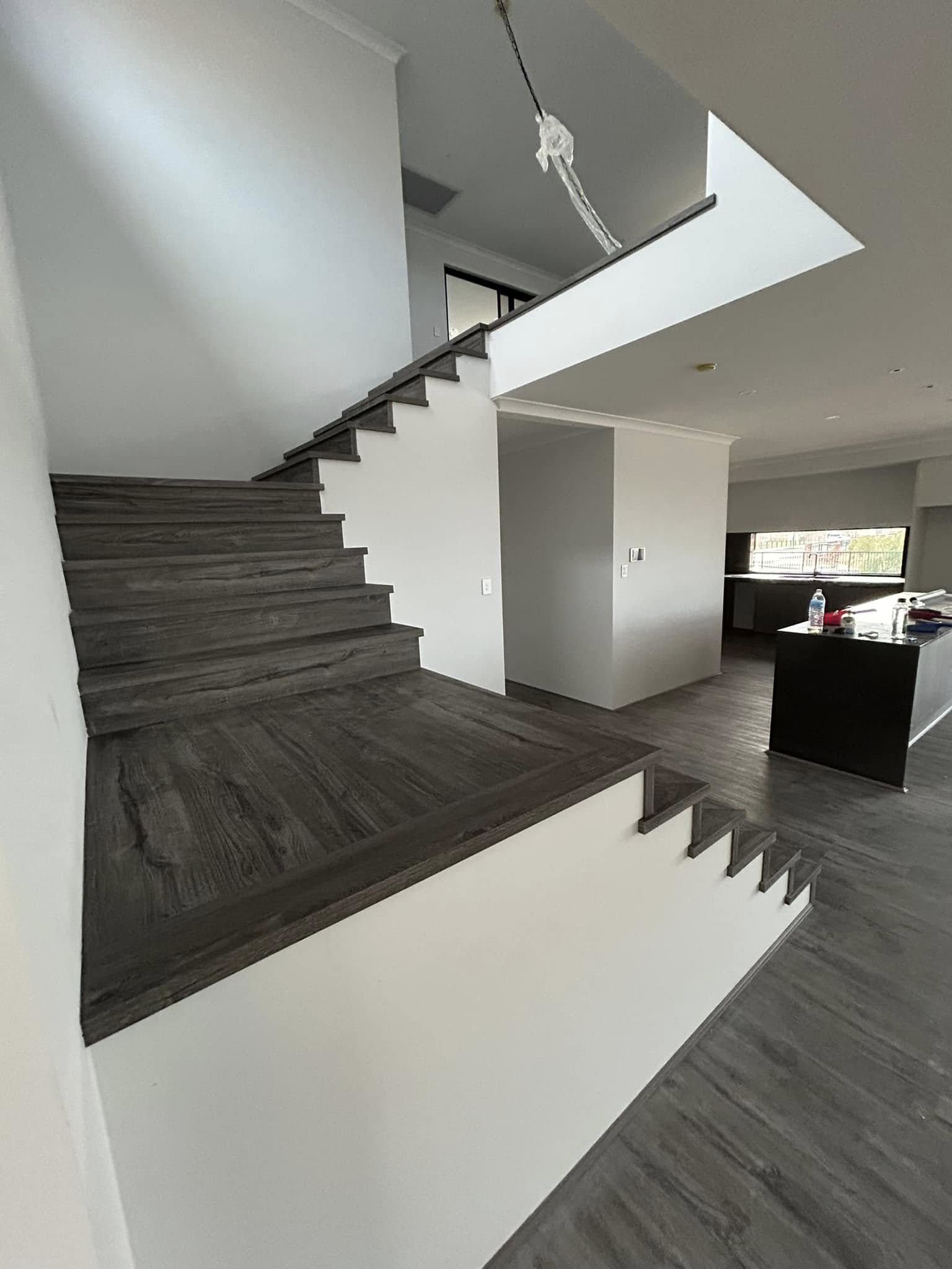 Grey timber-look staircase rising to an upstairs landing