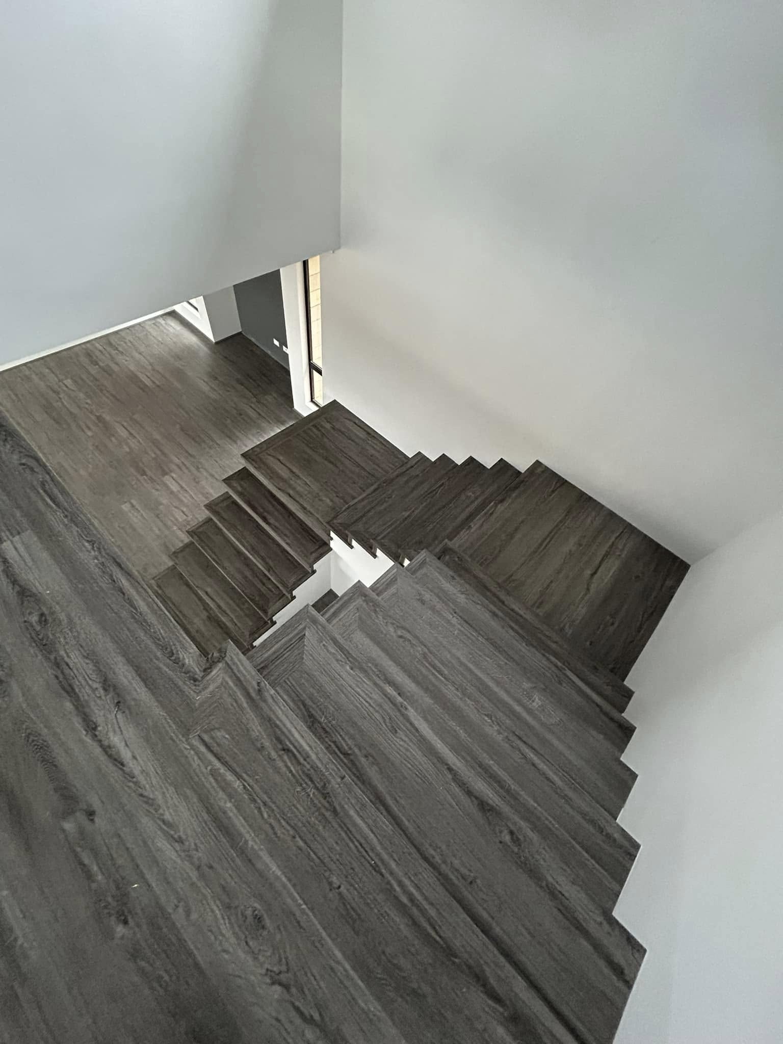 Grey timber-look stair treads seen from the top of the staircase