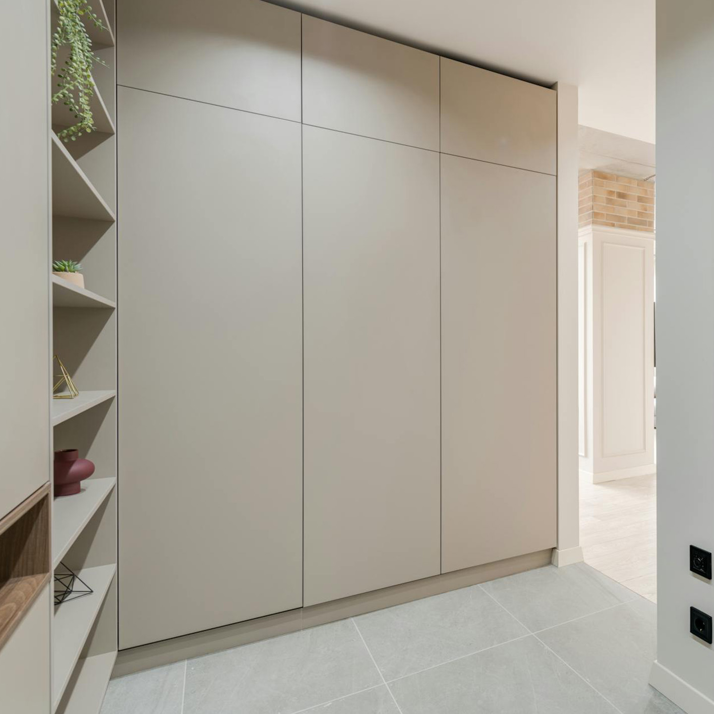 Built-in wardrobe with tall handleless doors and open side shelves