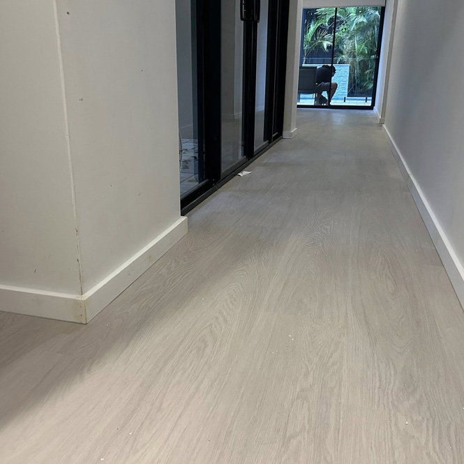 Hallway with light timber-look floor and white skirting boards