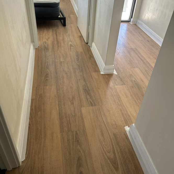 White skirting boards along a timber-look floor in a hallway
